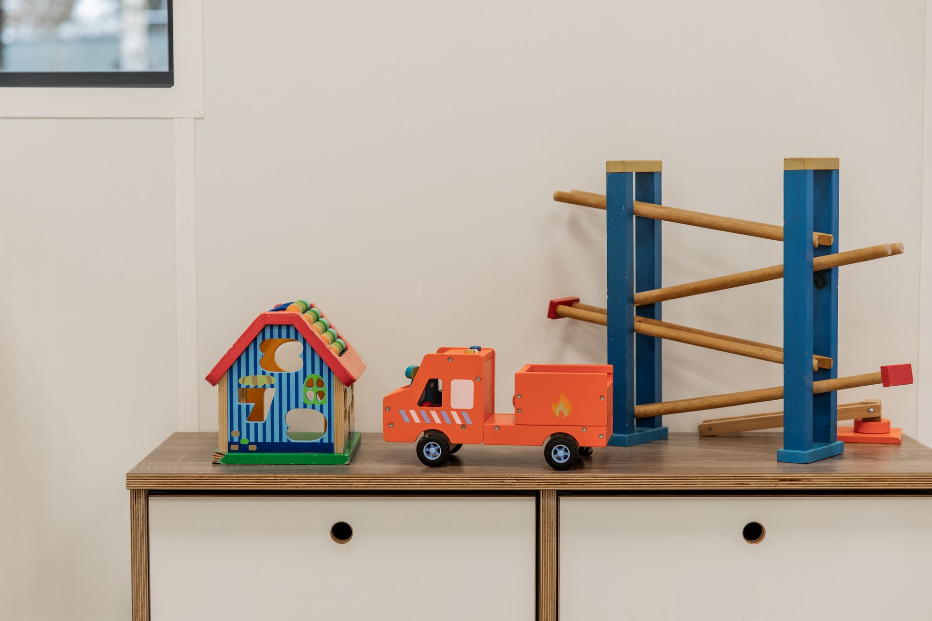 Houten speelgoed op een kast in het kinderdagverblijf