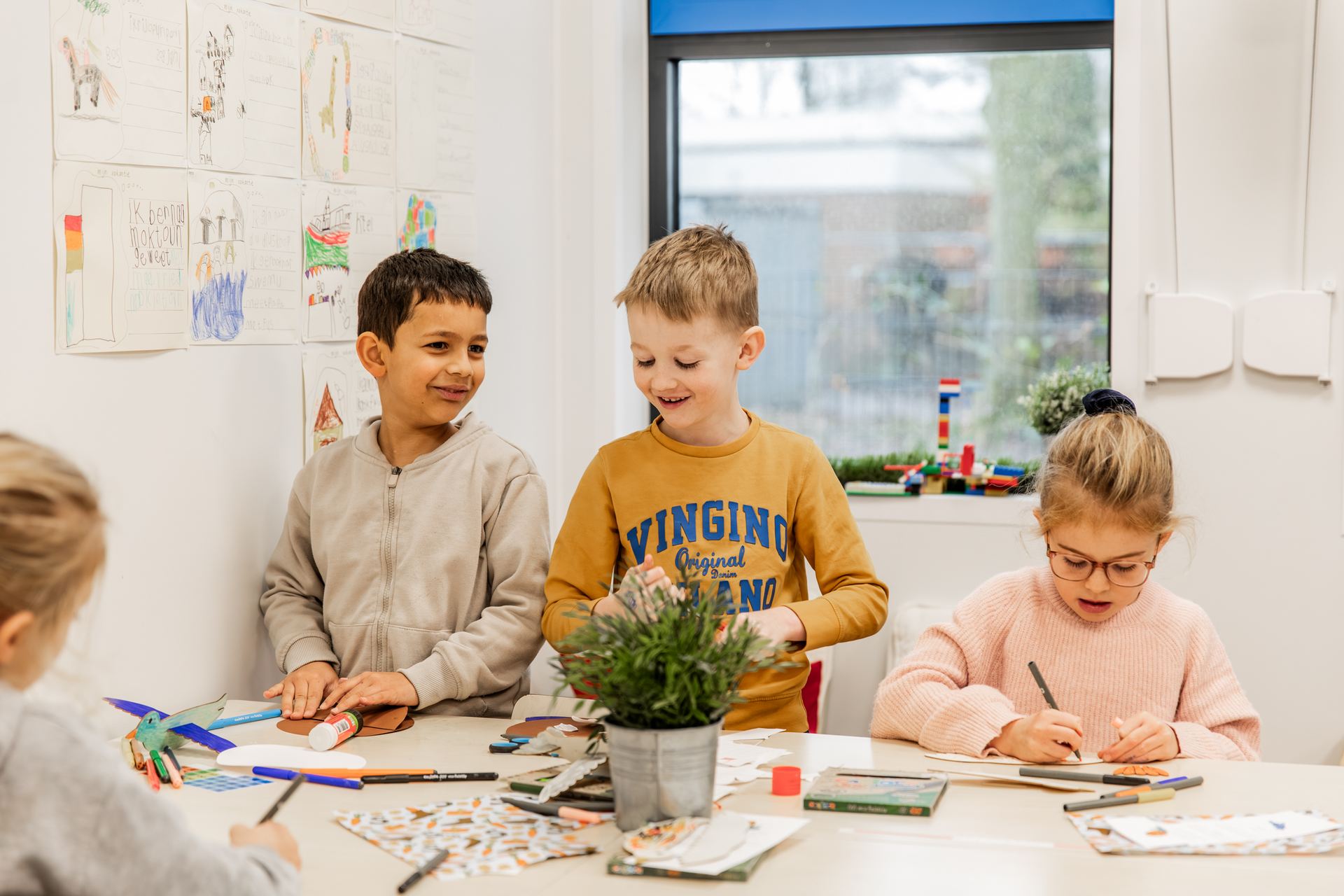 Kinderen knutselen samen aan een tafel in de klas