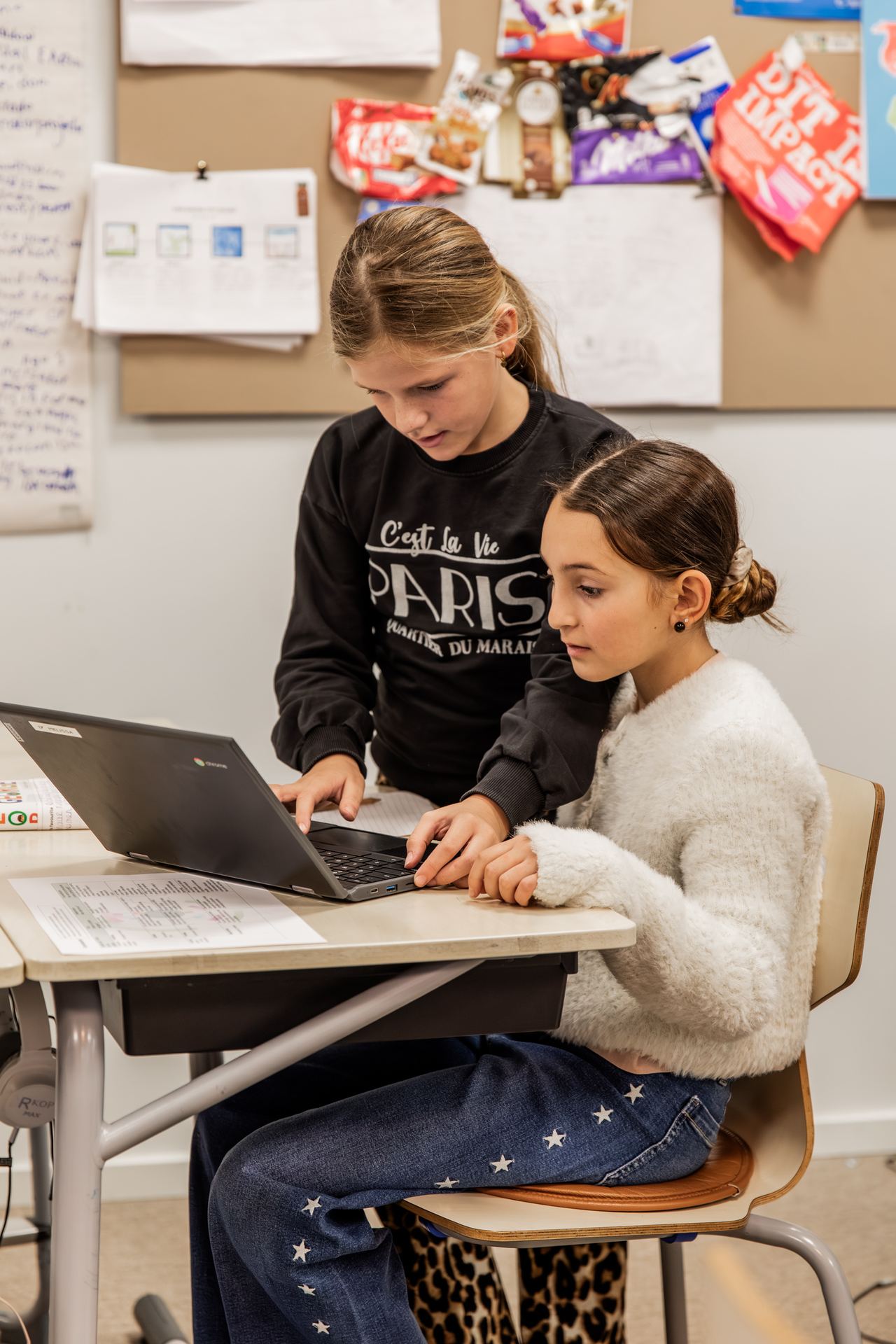 Twee meisjes werken samen op een laptop