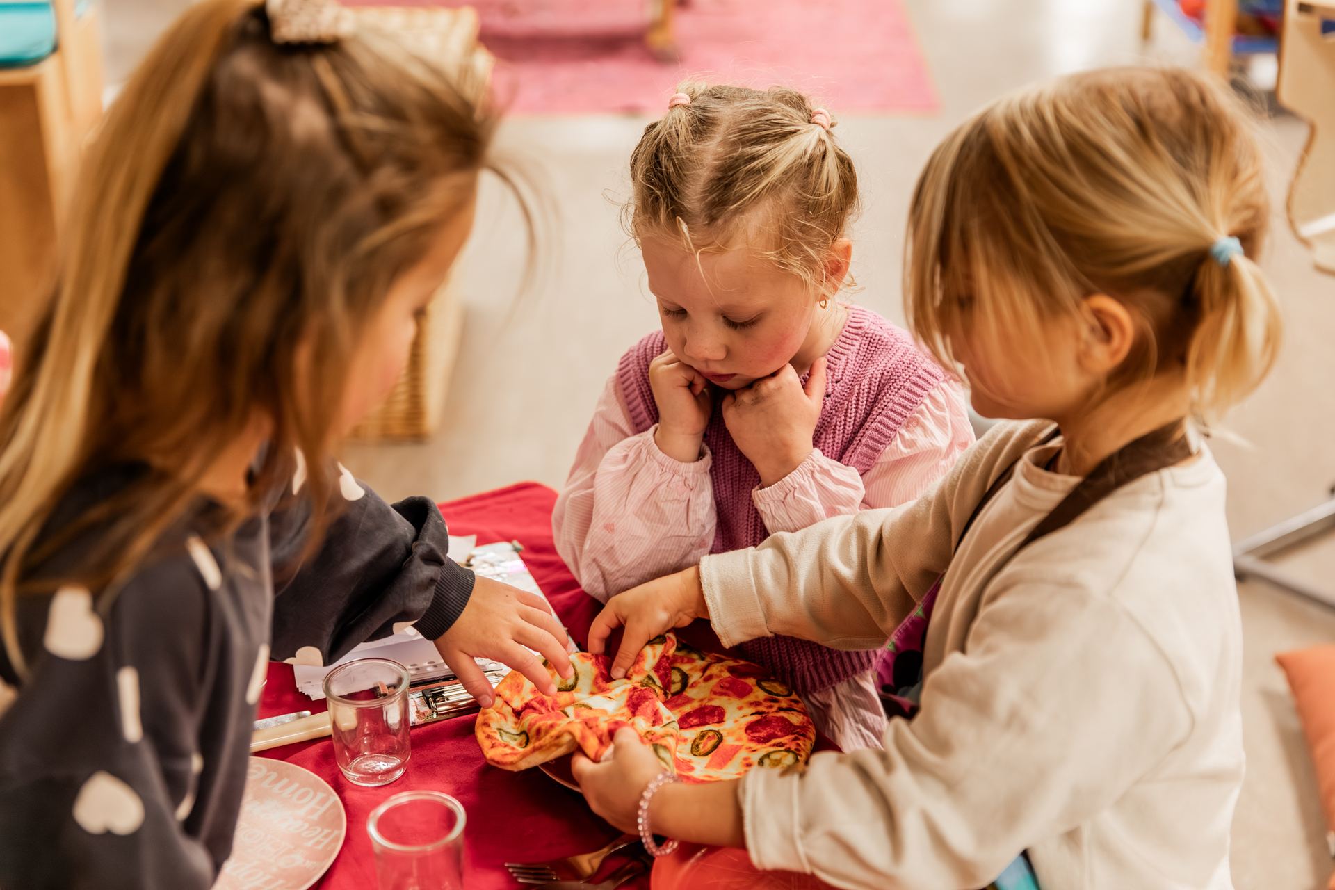 Kleuters maken samen pizza in het restaurant van hun spelverhaal