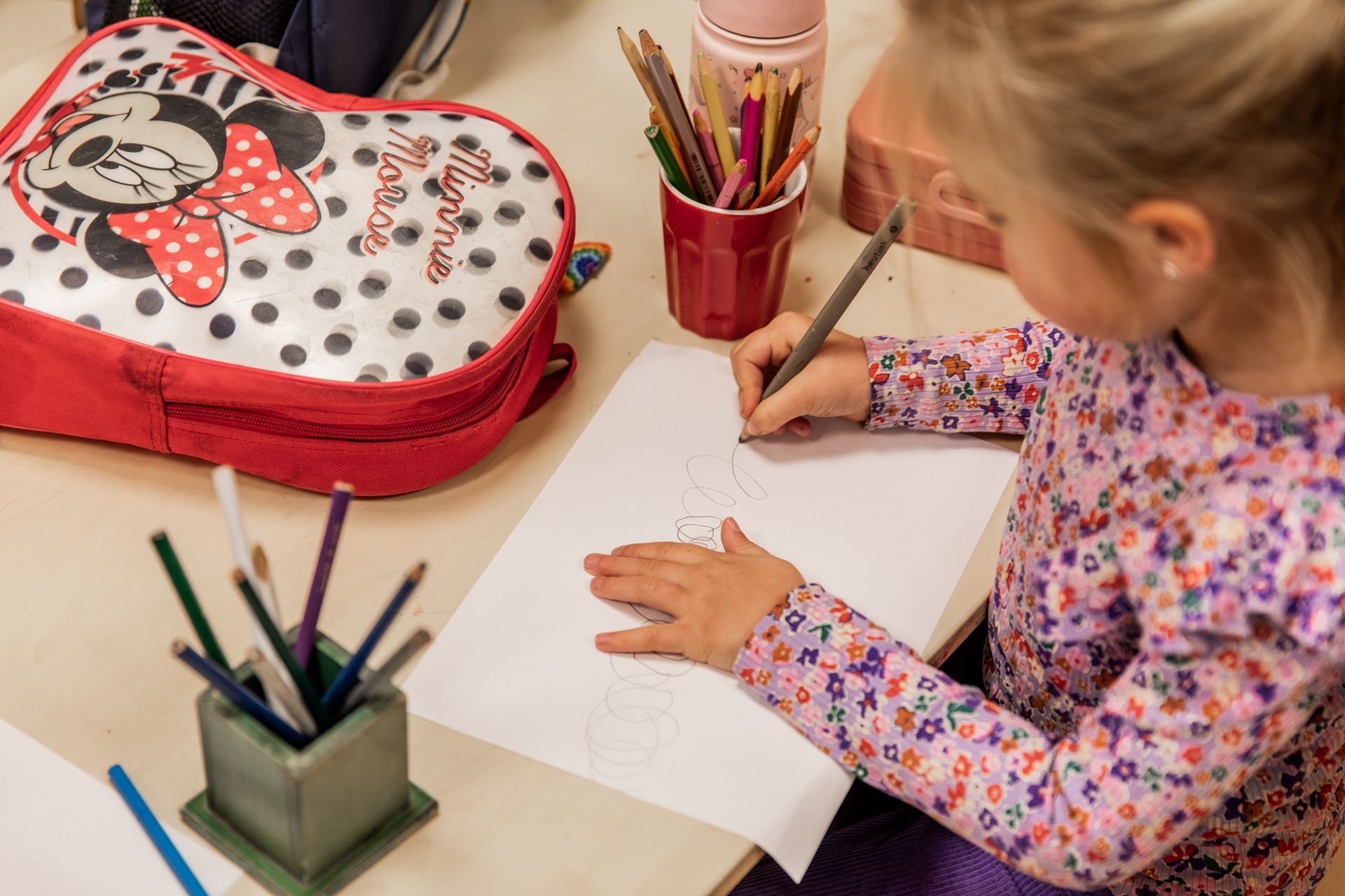 Kleuters tekenen met kleurpotloden aan tafel